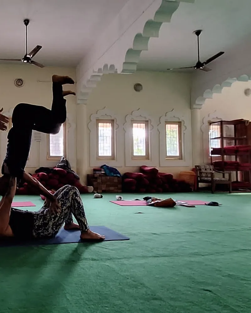 Teacher offering hands-on guidance during yoga practice training