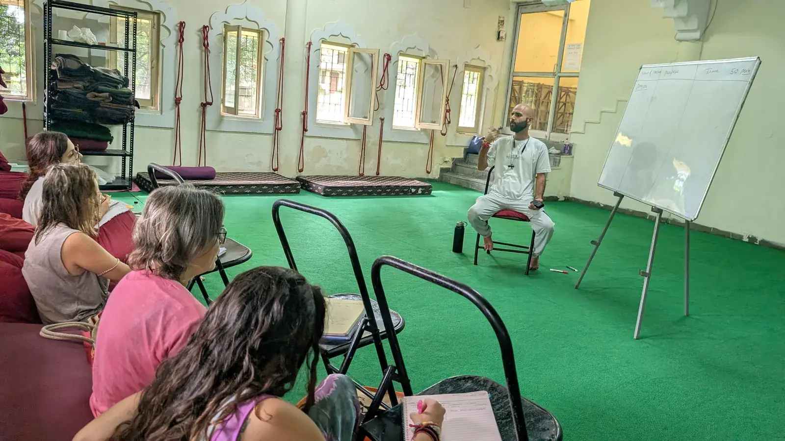 Studierende lernen Yoga-Philosophie in einer Kleingruppen-Klasse in Rishikesh