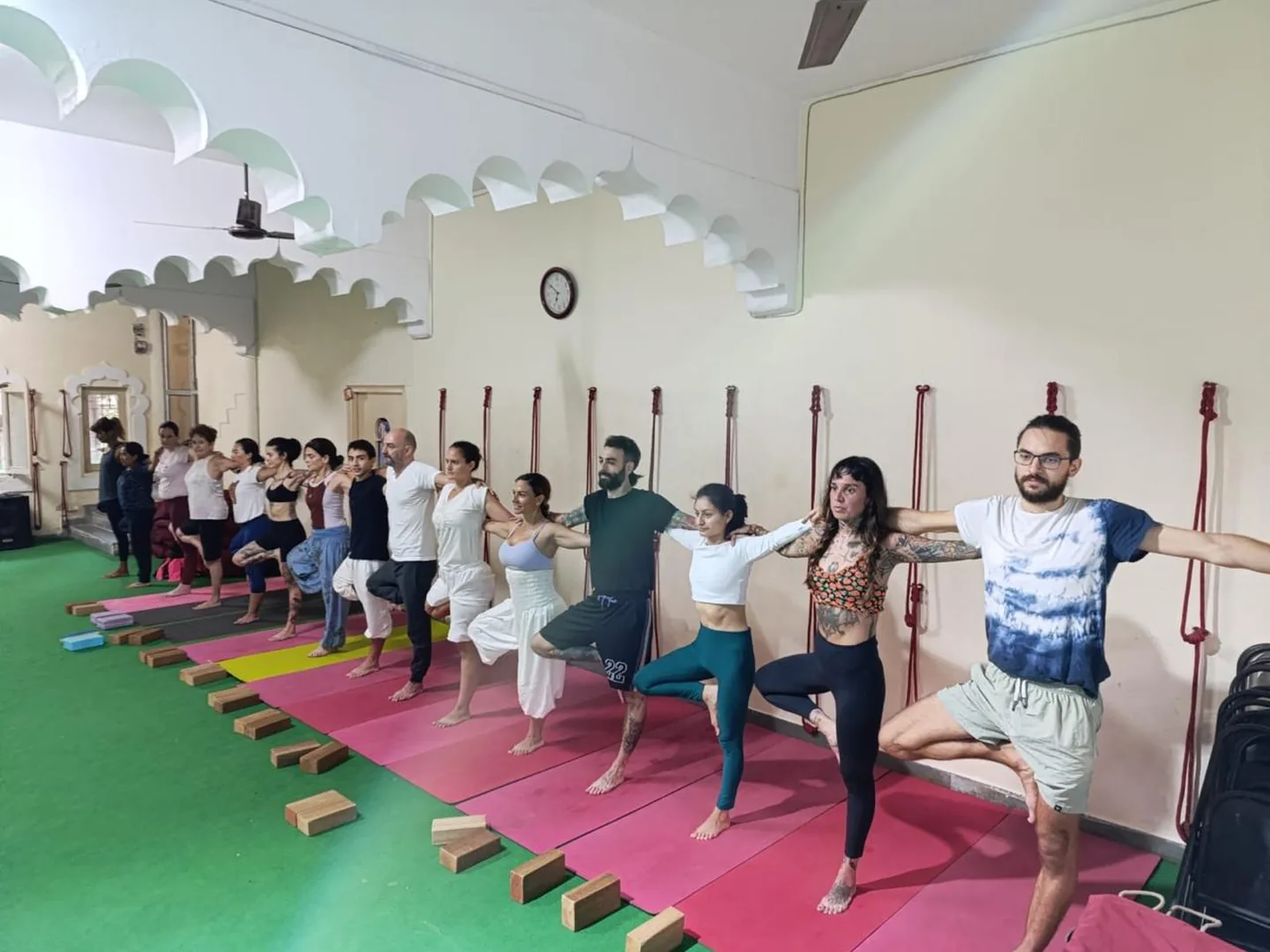 Studierende der Yogalehrerausbildung üben gemeinsam Asanas in Rishikesh
